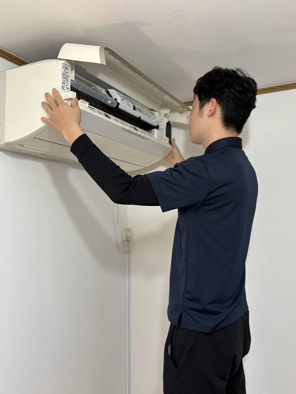 エアコンの状態を確認しながら作業するRoyal Supportの男性スタッフ