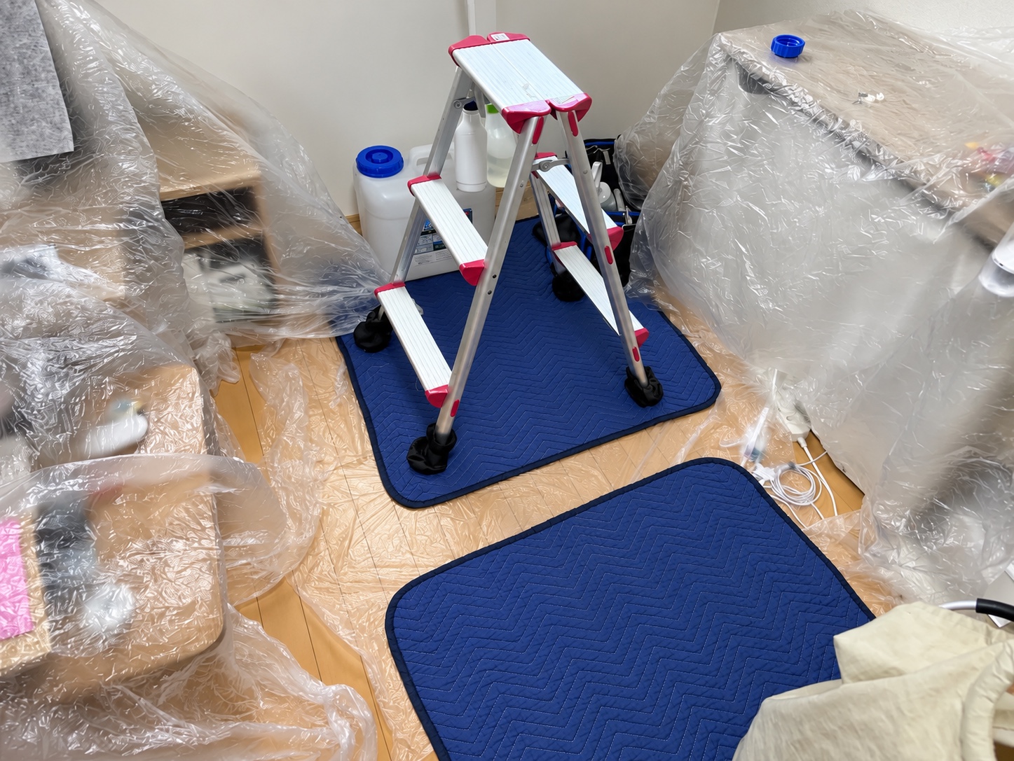 エアコンの下の寝具や家具を広くシートで覆った室内の養生